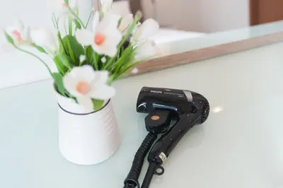 a camera on a counter next to a vase of flowers at Soho Suites KLCC by Leala in Kuala Lumpur