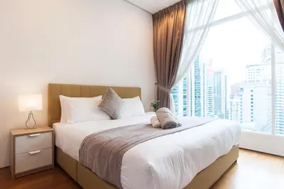 a bedroom with a large bed with a large window at Soho Suites KLCC by Leala in Kuala Lumpur