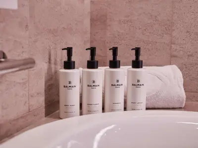 a group of three shampoo bottles sitting on top of a sink at Sofitel Kuala Lumpur Damansara in Kuala Lumpur