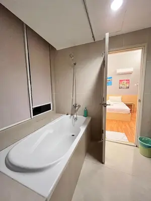 a white bath tub in a bathroom with a bedroom at Parkview Suite KLCC, Bernice in Kuala Lumpur