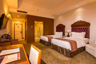 a hotel room with two beds and a table at Royale Chulan Kuala Lumpur in Kuala Lumpur