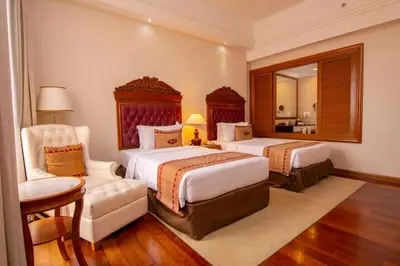a hotel room with two beds and a mirror at Royale Chulan Kuala Lumpur in Kuala Lumpur
