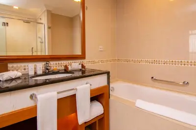 a bathroom with a sink and a tub and a mirror at Royale Chulan Kuala Lumpur in Kuala Lumpur