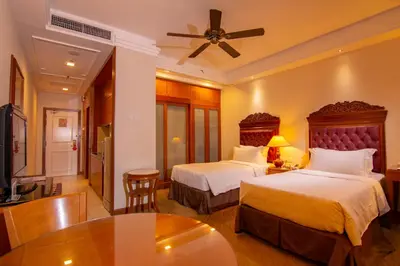 a hotel room with two beds and a table at Royale Chulan Kuala Lumpur in Kuala Lumpur