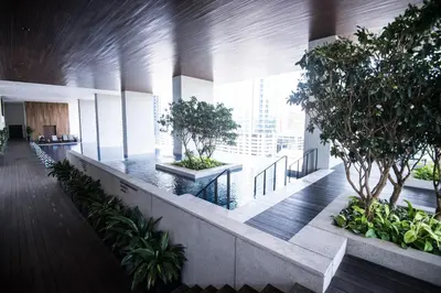 an office building hallway with trees and plants at KL Sentral Bangsar Suites EST BY PSM LUXURY SUITES in Kuala Lumpur
