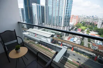 a room with a balcony with a view of a city at KL Sentral Bangsar Suites EST BY PSM LUXURY SUITES in Kuala Lumpur