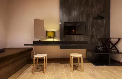 a hotel room with a bar with two stools and a tv at Hotel Twenty 8B in Kuala Lumpur