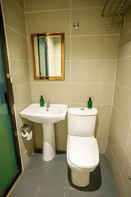a bathroom with a toilet and a sink at Alaxis Hotel in Kuala Lumpur