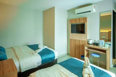 a hotel room with two beds and a dog laying on the bed at Alaxis Hotel in Kuala Lumpur