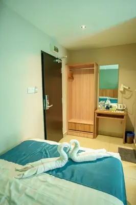 a bedroom with a bed with two swans on it at Alaxis Hotel in Kuala Lumpur