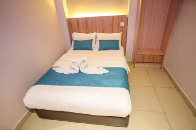 a bedroom with a bed with two towels on it at Alaxis Hotel in Kuala Lumpur
