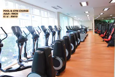 a gym with rows of treadmills in a room at Soho Suites KLCC by 21 Century travel in Kuala Lumpur
