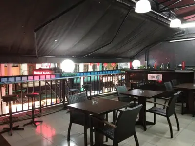 a restaurant with tables and chairs and a bar at Petaling Street Hotel Chinatown in Kuala Lumpur