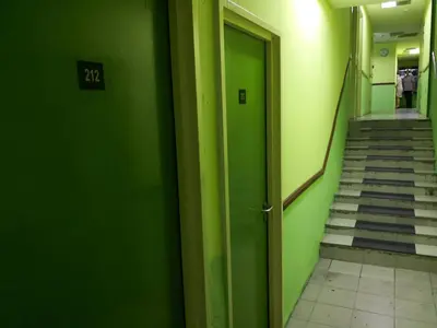 a hallway with green walls and stairs with a door at Petaling Street Hotel Chinatown in Kuala Lumpur
