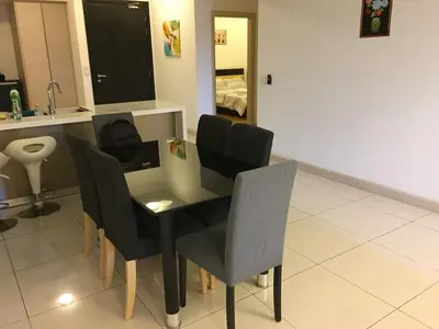 a table and chairs in a room with a bedroom at Apartment by WGS Homestay Bukit Bintang in Kuala Lumpur