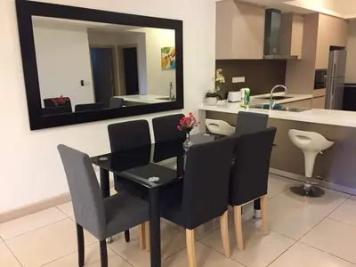 a dining room table with black chairs and a mirror at Apartment by WGS Homestay Bukit Bintang in Kuala Lumpur