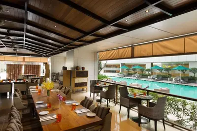 a dining room with a pool in the background at DoubleTree By Hilton Kuala Lumpur in Kuala Lumpur