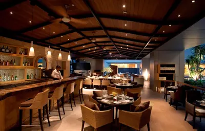a restaurant with tables and chairs and a bar at DoubleTree By Hilton Kuala Lumpur in Kuala Lumpur