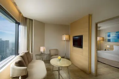 a hotel room with a bed and a couch and a table at DoubleTree By Hilton Kuala Lumpur in Kuala Lumpur