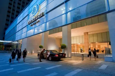 a car parked outside of a building with people walking outside at DoubleTree By Hilton Kuala Lumpur in Kuala Lumpur