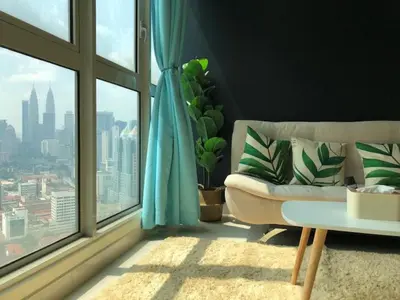 a living room with a couch and a large window at Suites & Residences @ Regalia by PLC in Kuala Lumpur