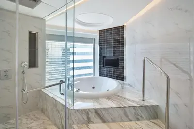 a bathroom with a tub and a glass shower at Le Méridien Kuala Lumpur in Kuala Lumpur