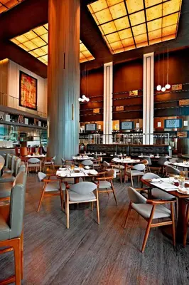 a restaurant with tables and chairs in a room at Le Méridien Kuala Lumpur in Kuala Lumpur