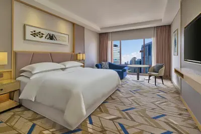 a bedroom with a large bed and a living room at Sheraton Imperial Kuala Lumpur Hotel in Kuala Lumpur