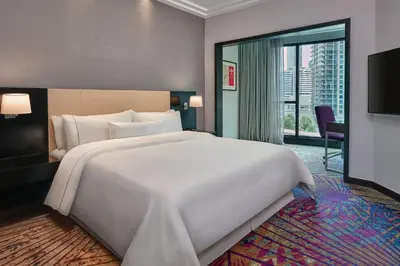 a large white bed in a room with a large window at The Westin Kuala Lumpur in Kuala Lumpur