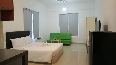 a bedroom with a bed and a green chair at Maytower Service Suite - Masjid India in Kuala Lumpur