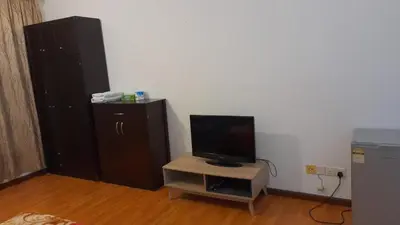 a room with a tv and a small table with a small cabinet at Maytower Service Suite - Masjid India in Kuala Lumpur