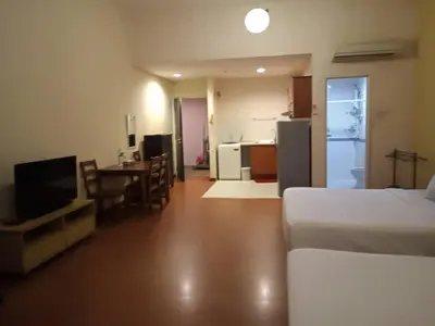a bedroom with a bed and a kitchen with a table at Maytower Service Suite - Masjid India in Kuala Lumpur