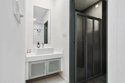 a bathroom with a white sink and a shower at Summer Suites KLCC Apartments by soulasia in Kuala Lumpur