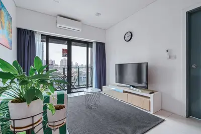 a living room with a flat screen tv and a plant at Summer Suites KLCC Apartments by soulasia in Kuala Lumpur
