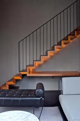 a living room with a couch and a staircase at MOV Hotel Kuala Lumpur in Kuala Lumpur