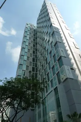 a tall glass building with a tree in front of it at Soho Suites KLCC by LX Suites 2 in Kuala Lumpur