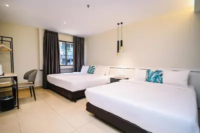 a hotel room with two beds and a desk at Kingston Hotel 1 - Bukit Bintang in Kuala Lumpur