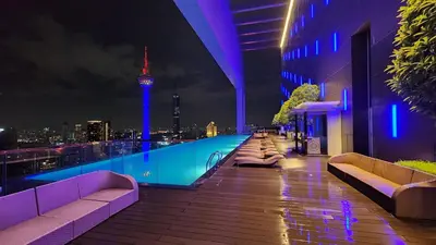 a rooftop pool with a view of the city at night at KL Platinum KLCC By Hive KL in Kuala Lumpur