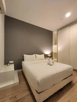a bedroom with a large white bed and a wall at KL Platinum KLCC By Hive KL in Kuala Lumpur