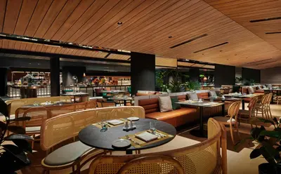 a restaurant with tables and chairs and a bar at PARKROYAL COLLECTION Kuala Lumpur in Kuala Lumpur