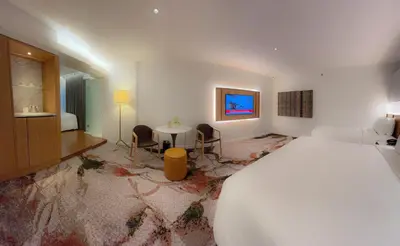 a bedroom with a large bed and a table and chairs at The Federal Kuala Lumpur in Kuala Lumpur