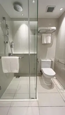 a bathroom with a toilet and a glass shower at The Federal Kuala Lumpur in Kuala Lumpur