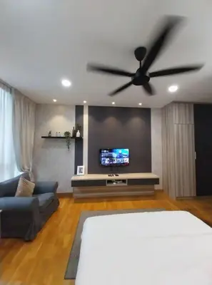 a living room with a ceiling fan and a tv at KL Gateway Residency in Kuala Lumpur