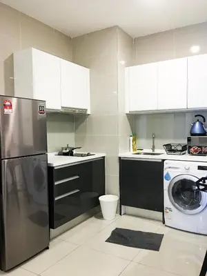 a kitchen with a refrigerator and a washer and dryer at KL Gateway Residency in Kuala Lumpur