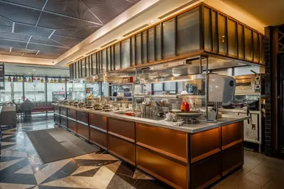 a large kitchen with a long counter in a restaurant at Micasa All Suites Hotel in Kuala Lumpur