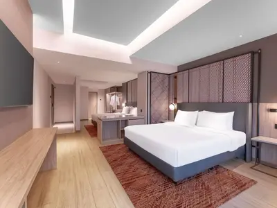 a bedroom with a large white bed and a desk at Grand Mercure Kuala Lumpur Bukit Bintang in Kuala Lumpur