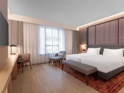 a hotel room with a bed and two chairs at Grand Mercure Kuala Lumpur Bukit Bintang in Kuala Lumpur