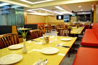 a restaurant with tables and chairs with plates and utensils at City Central Hotel in Kuala Lumpur