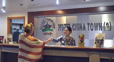 a woman standing at a bar getting her hair done at Hotel China Town 2 in Kuala Lumpur