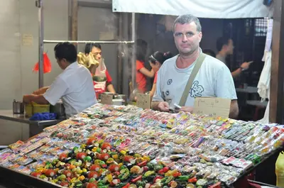a man standing in front of a table of food at Hotel China Town 2 in Kuala Lumpur